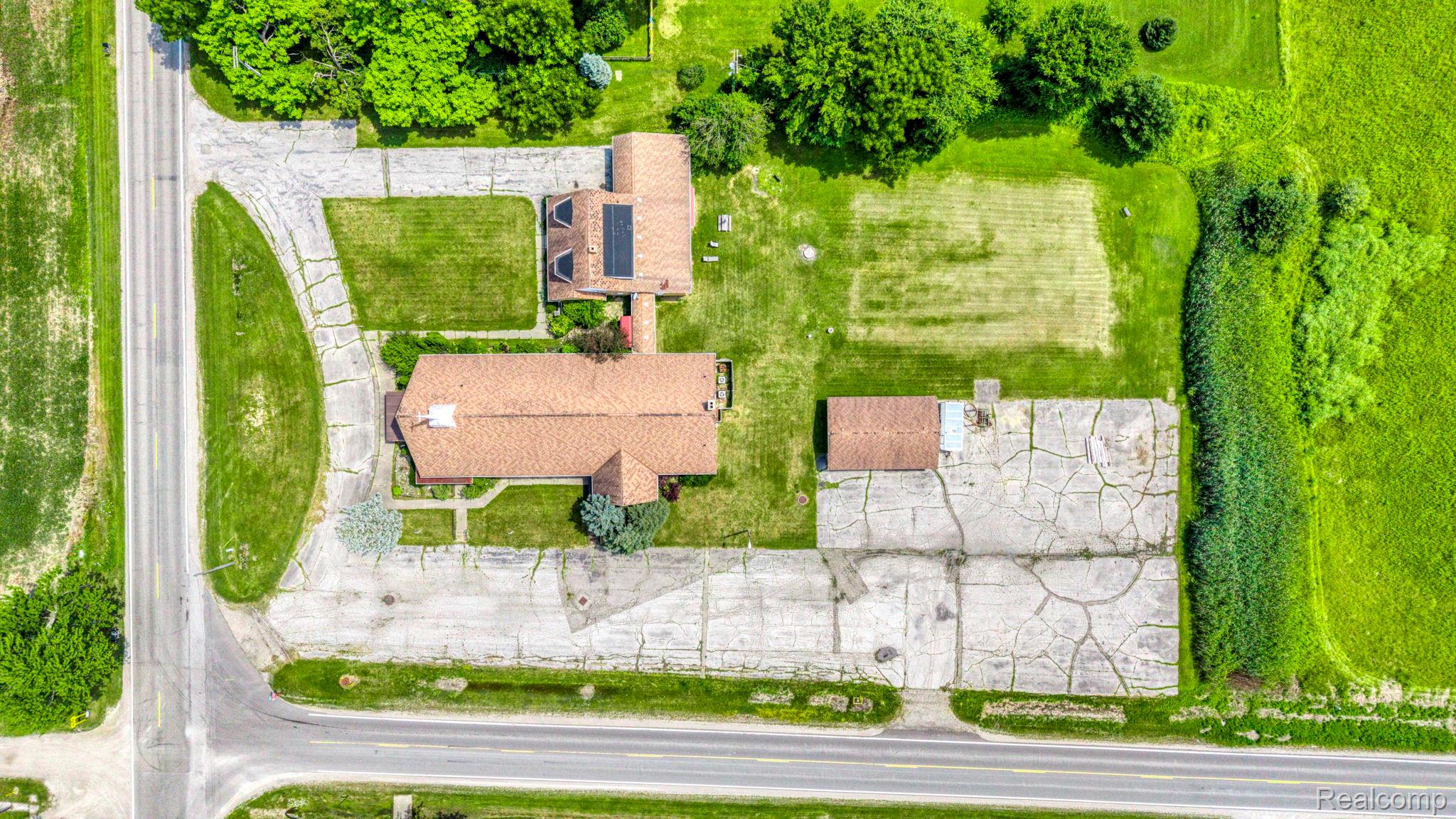 9735 Dolan Road Columbus, MI 48063 - Photo 11 of 63 Aerial perspective showcasing two distinct structures, expansive paved areas, and manicured lawns