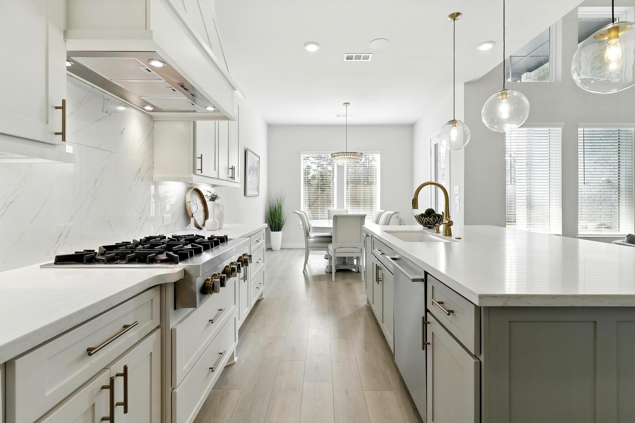 26923 Arethusa Court Spring, TX 77389 - Photo 9 of 44 This kitchen features a modern design with white cabinetry, stainless steel appliances, Light wood flooring enhances the airy, contemporary feel.