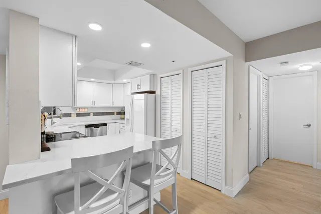 a kitchen with stainless steel appliances kitchen island granite countertop a refrigerator and cabinets