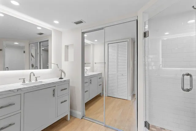 a bathroom with a double vanity sink mirror and shower