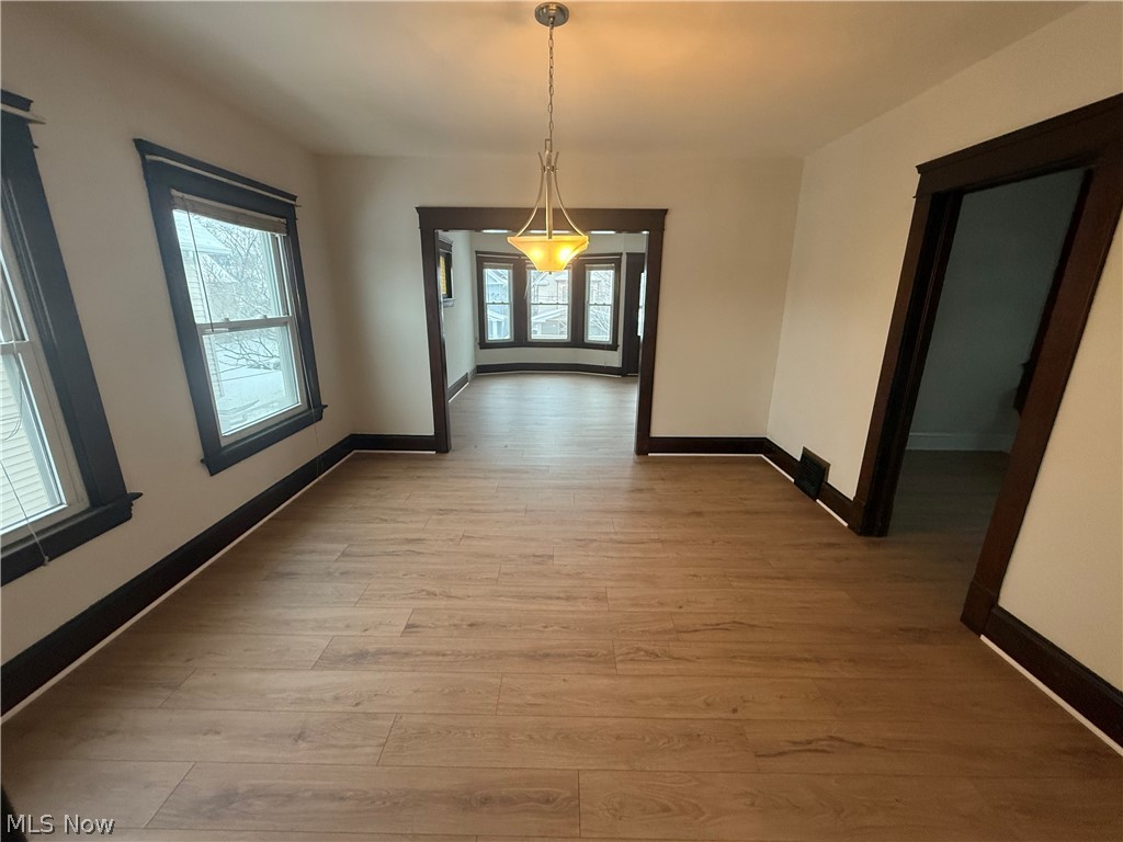 3612 Riverside Avenue Cleveland, OH 44109 - Photo 8 of 22 Spacious room featuring wood-finish flooring, white walls, and dark wood trim
