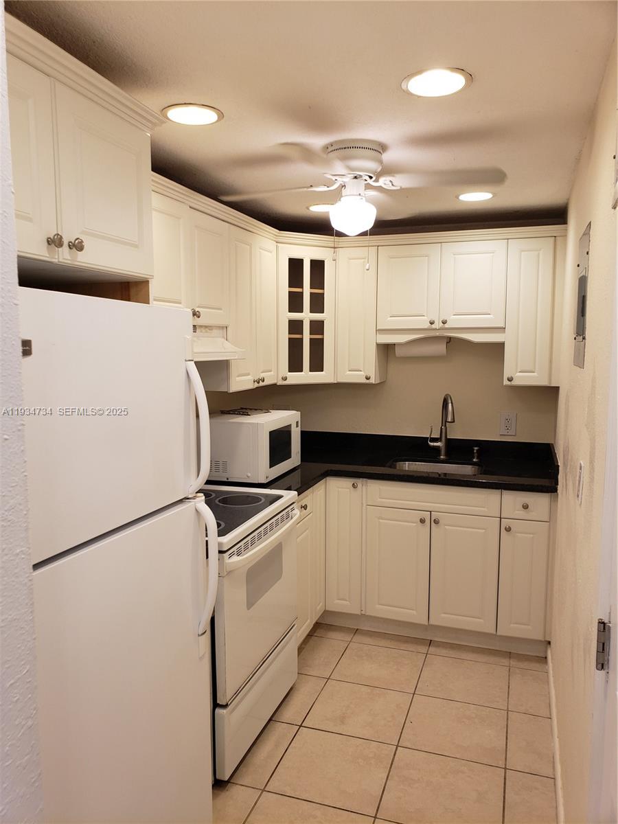 200 South Birch Road, Unit 203 Fort Lauderdale, FL 33316 - Photo 3 of 10 a kitchen with granite countertop white cabinets and white appliances