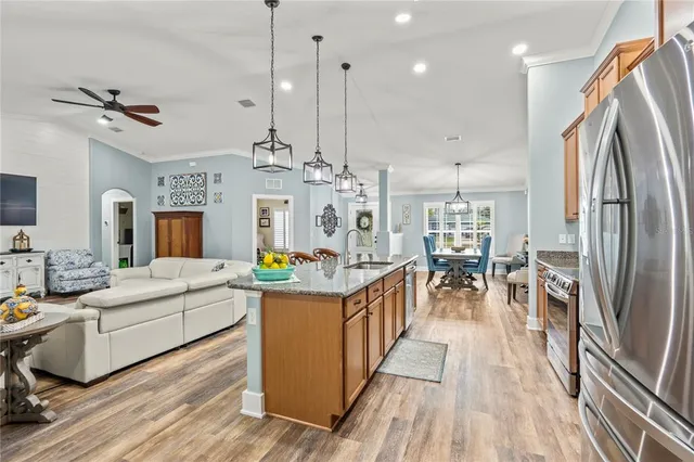 a kitchen with stainless steel appliances granite countertop a refrigerator a stove top oven a sink and dishwasher