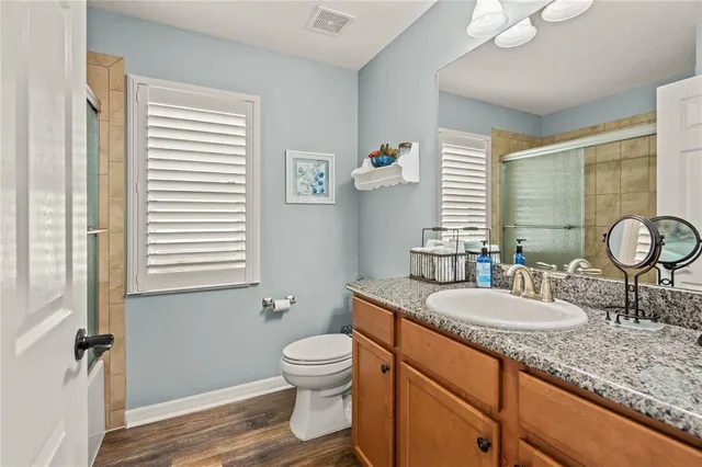 a view of a patio with couches table and chairs under an umbrella with potted plants