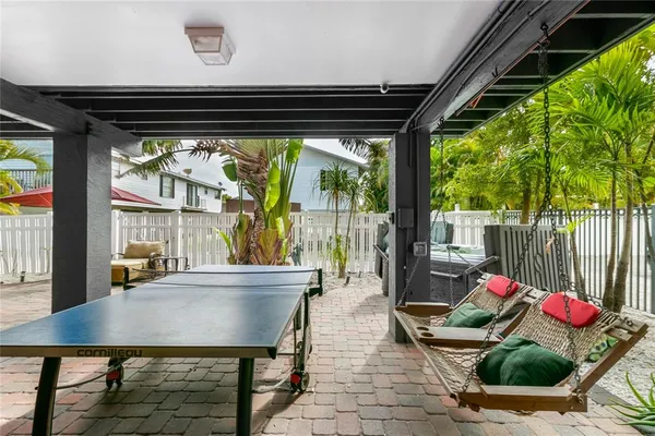 a patio with table and chairs and potted plants