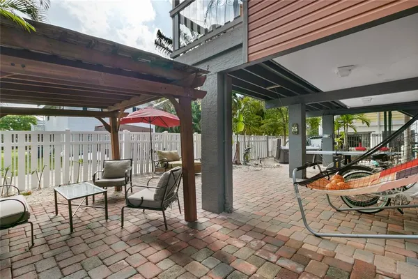 a view of a patio with table and chairs potted plants and floor to ceiling window