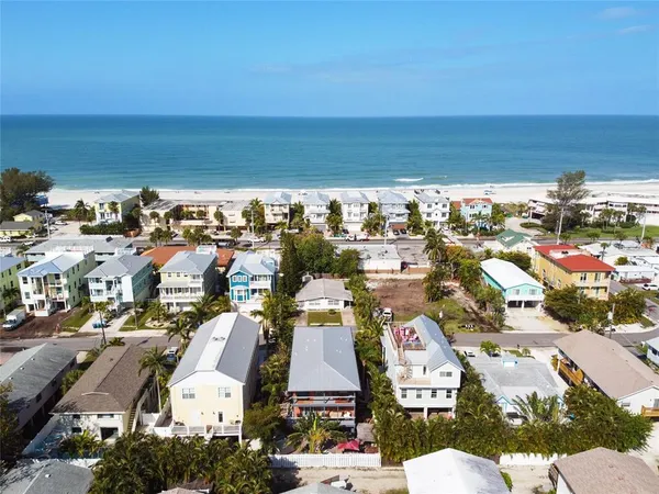 an aerial view of a city with lots of residential buildings and ocean view