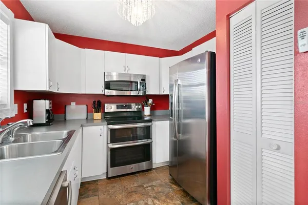 a kitchen with stainless steel appliances granite countertop a refrigerator and a sink