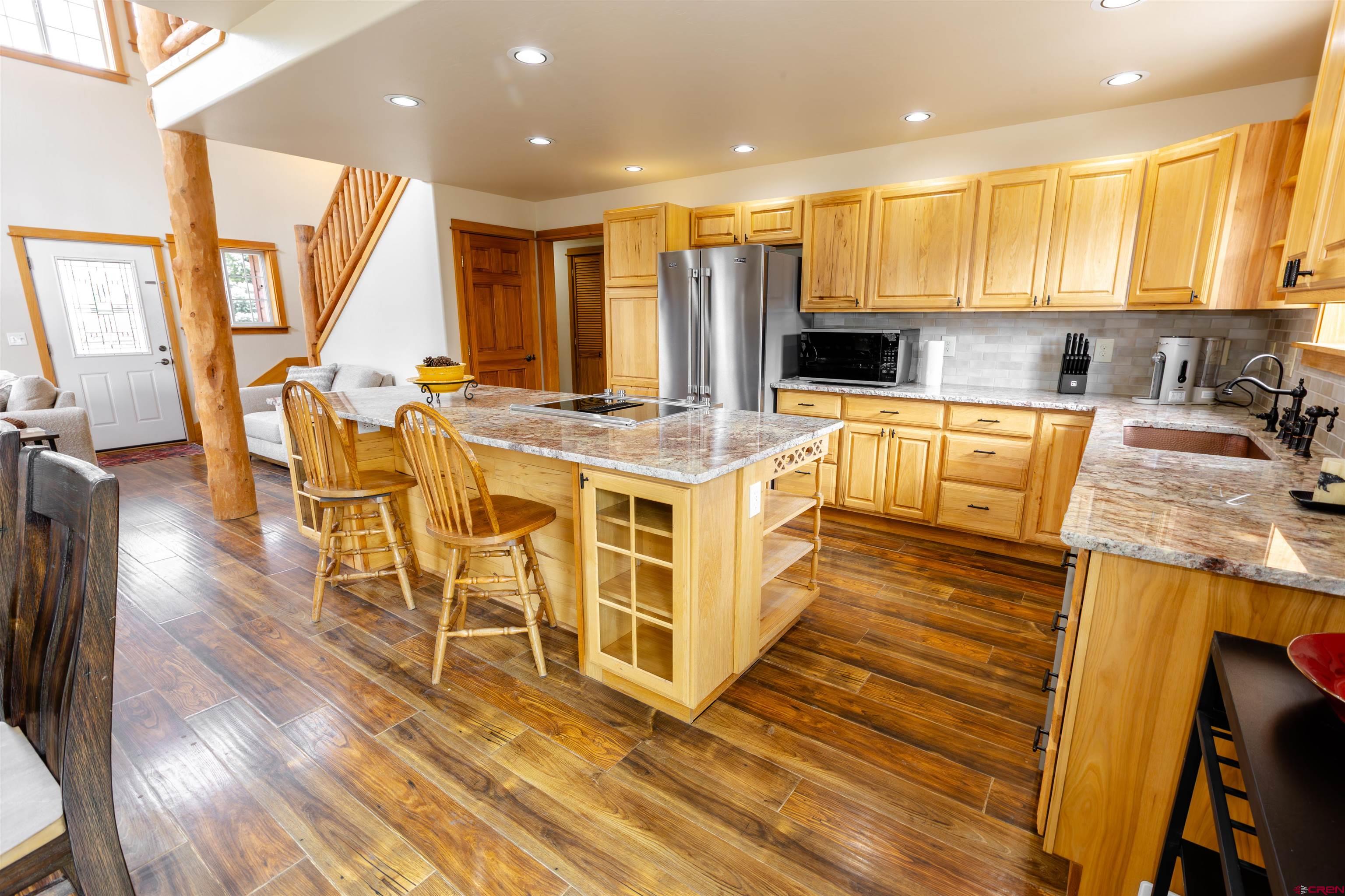 312 Main Street Pitkin, CO 81241 - Photo 12 of 38 a large kitchen with stainless steel appliances granite countertop a stove a sink dishwasher and a refrigerator with wooden floor
