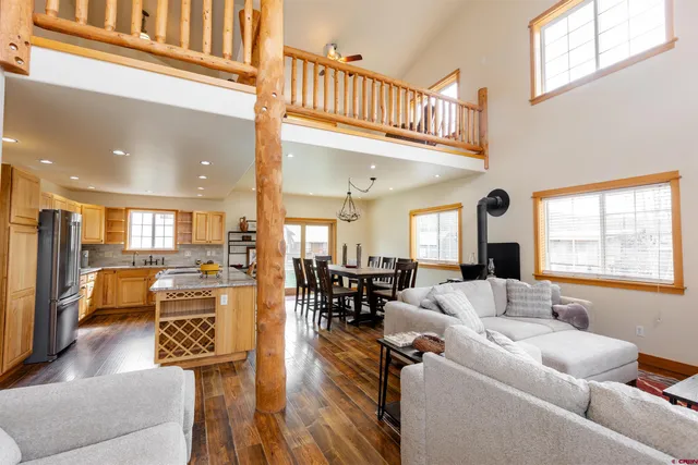 a living room with furniture wooden floor and a large window