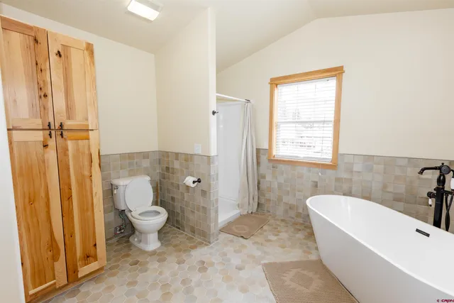 a bathroom with a toilet a sink a mirror and bathtub