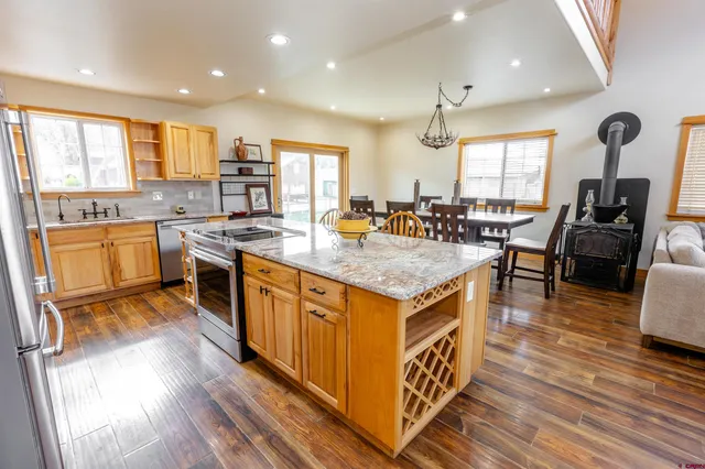 a kitchen with stainless steel appliances granite countertop a sink stove and wooden floor