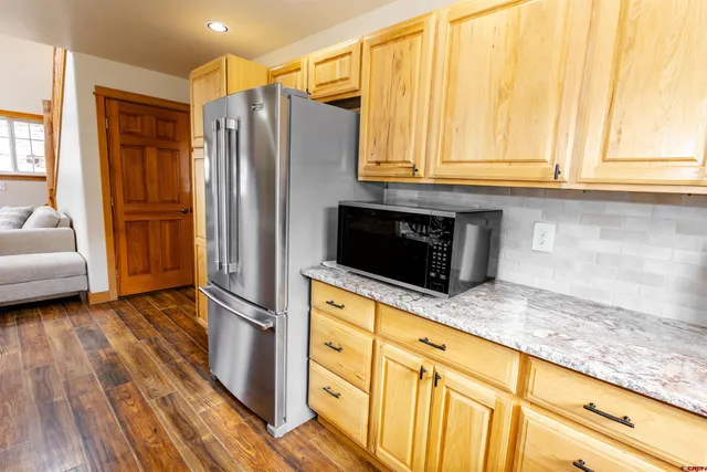 a kitchen with stainless steel appliances granite countertop a refrigerator and a stove top oven