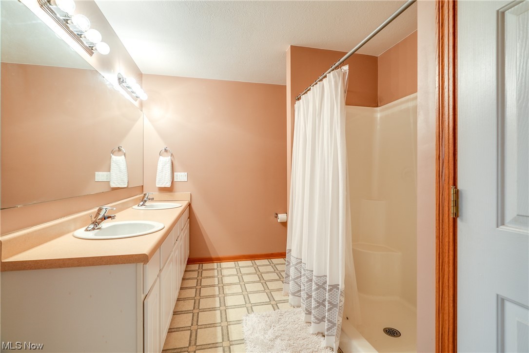 8837 Spieth Road Litchfield, OH 44253 - Photo 25 of 35 Owner's bath with dual sinks, walk-in shower, and a large walk-in closet.