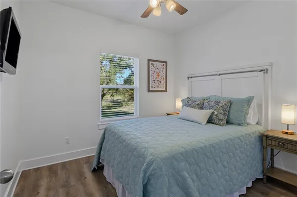 a bedroom with a bed and a flat tv screen on dresser