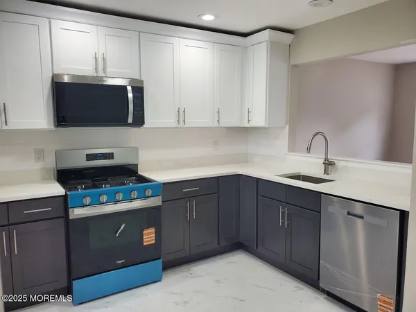a kitchen with stainless steel appliances granite countertop a sink stove and microwave