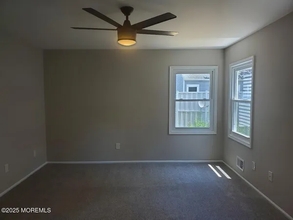 an empty room with a window and a fan