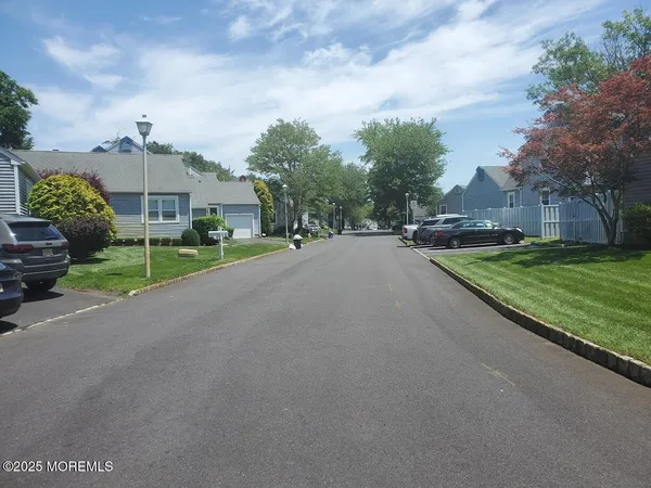a view of a house with a big yard and large trees