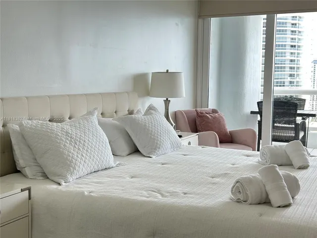 a large bed sitting in a bedroom next to a window