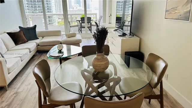 a view of a dining room with furniture large windows and wooden floor