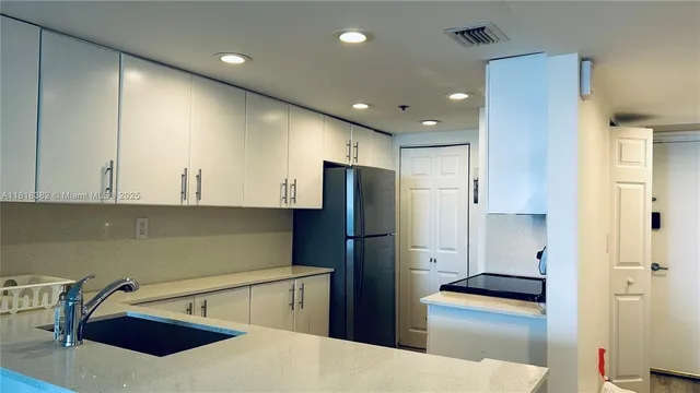 a kitchen with a refrigerator and a sink
