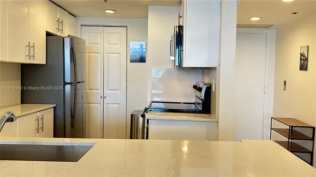 a kitchen with stainless steel appliances kitchen island a refrigerator sink and stove