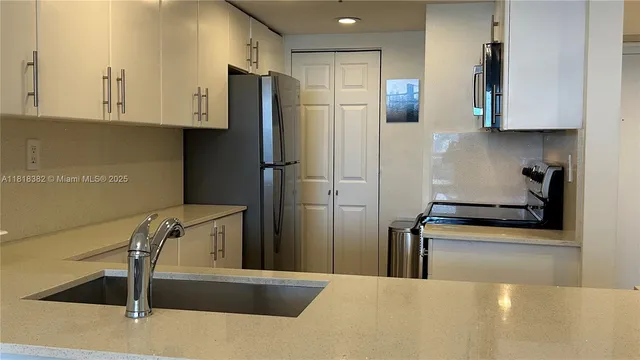 a kitchen with stainless steel appliances granite countertop a refrigerator and a sink