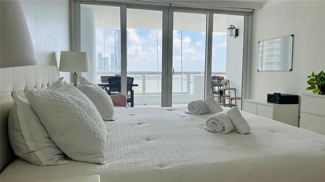 a large bed sitting in a bedroom next to a window