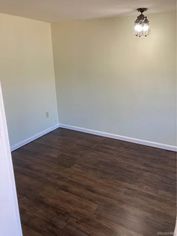 a view of a room with wooden floor and a ceiling fan