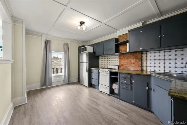 a kitchen with stainless steel appliances granite countertop a refrigerator and a stove top oven