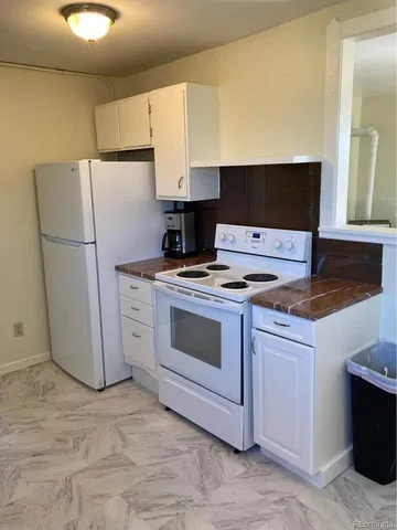 a kitchen with a stove cabinets and refrigerator