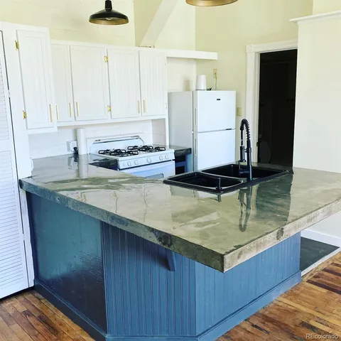 a kitchen with a sink refrigerator and cabinets