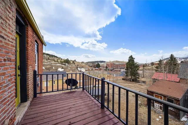 a view of a balcony with wooden floor & fence