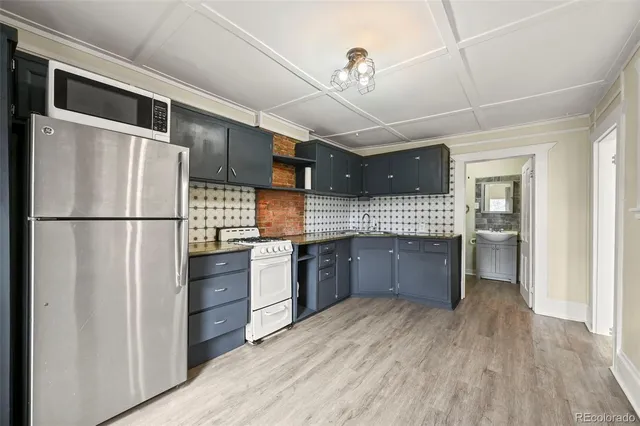 a kitchen with stainless steel appliances granite countertop a refrigerator a sink dishwasher a stove and a refrigerator