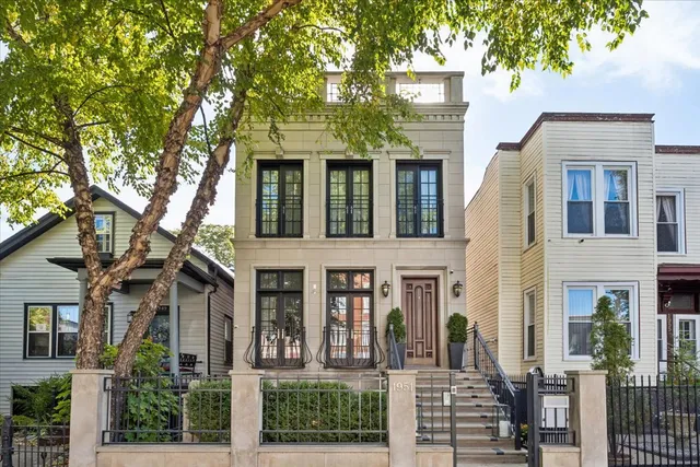 a view of a brick house with large windows and a large tree