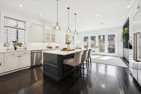 a hallway with white cabinets and outdoor space