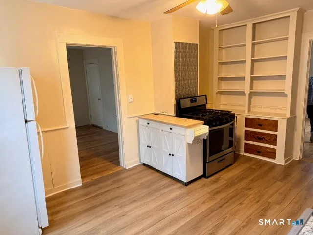 a kitchen with a stove and wooden floor
