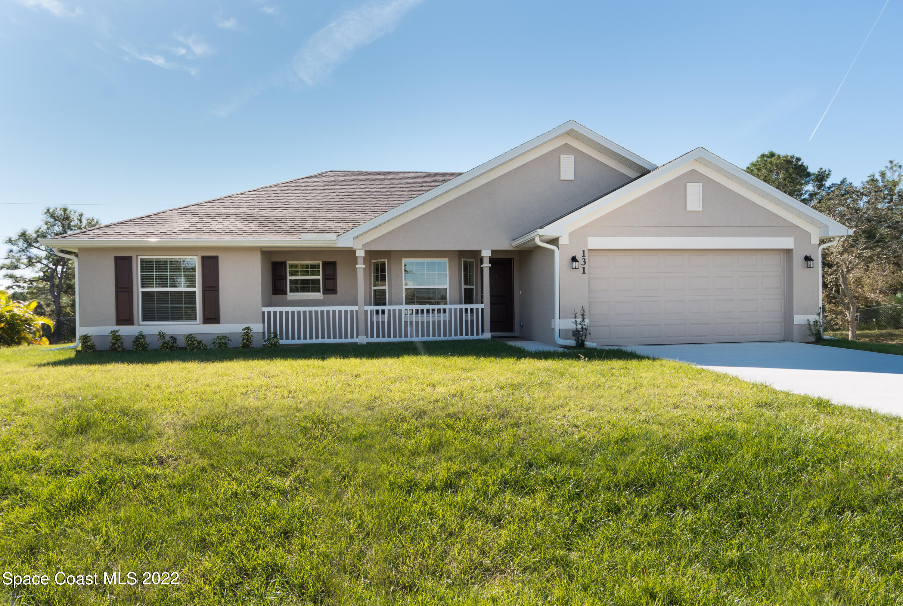 1490 Saxony Road Southwest Palm Bay, FL 32908 - Photo 1 of 15 a view of a house with a yard and garage