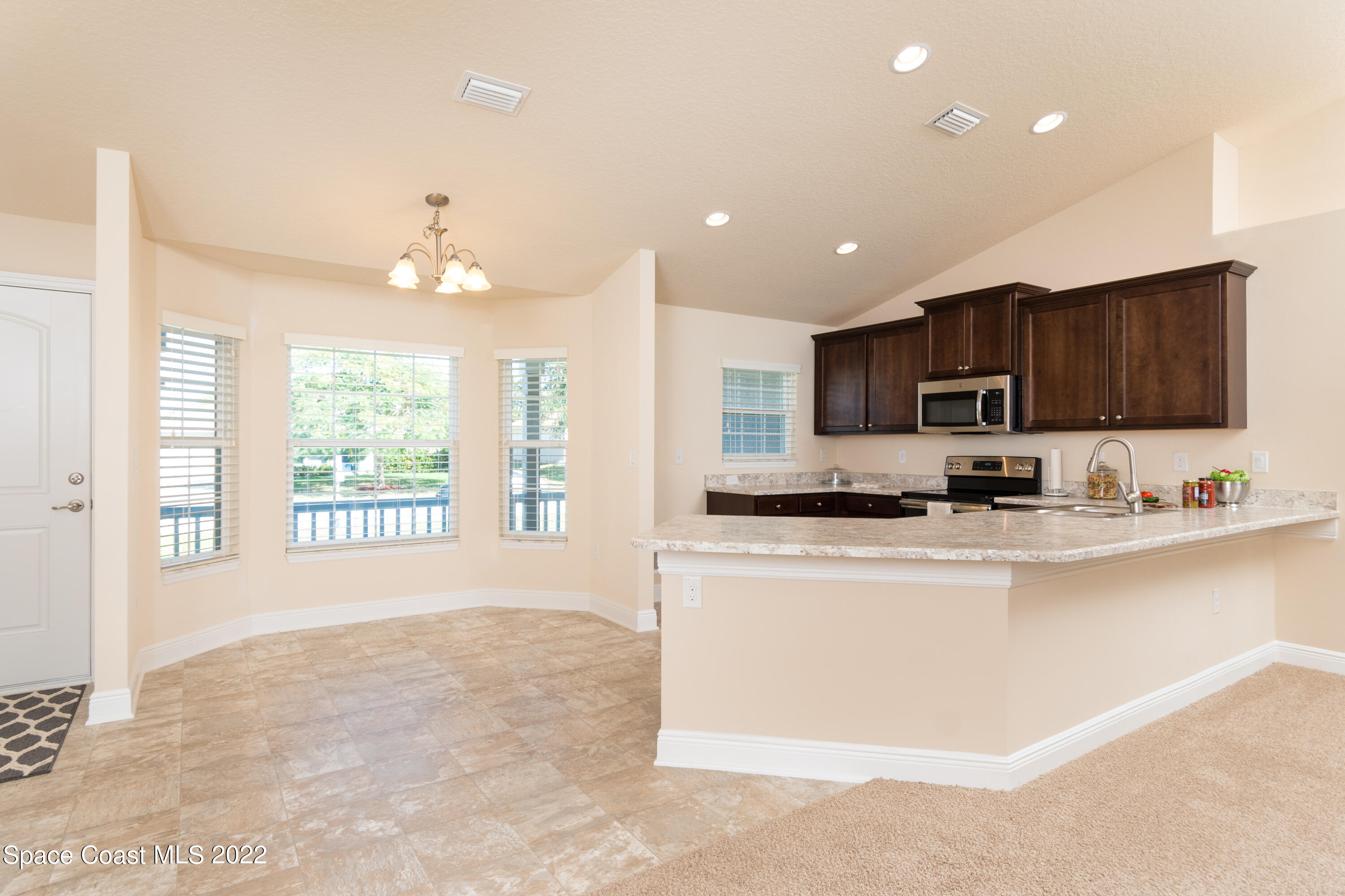 1490 Saxony Road Southwest Palm Bay, FL 32908 - Photo 5 of 15 a large kitchen with kitchen island granite countertop a large window and a sink