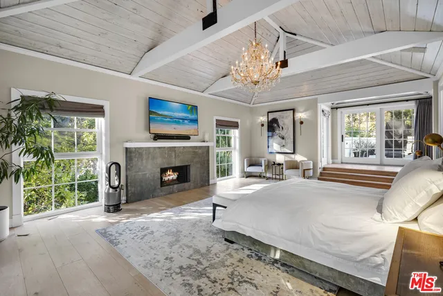 a spacious bedroom with a large bed and a fireplace