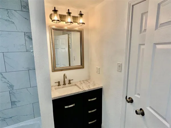 a white toilet and tub sitting next to a bathroom sink