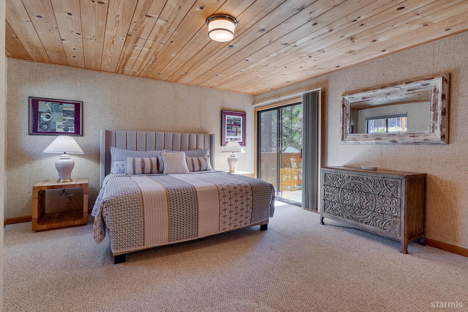 345 Granite Drive Stateline, NV 89449 - Photo 11 of 24 a spacious bedroom with a bed and a chandelier