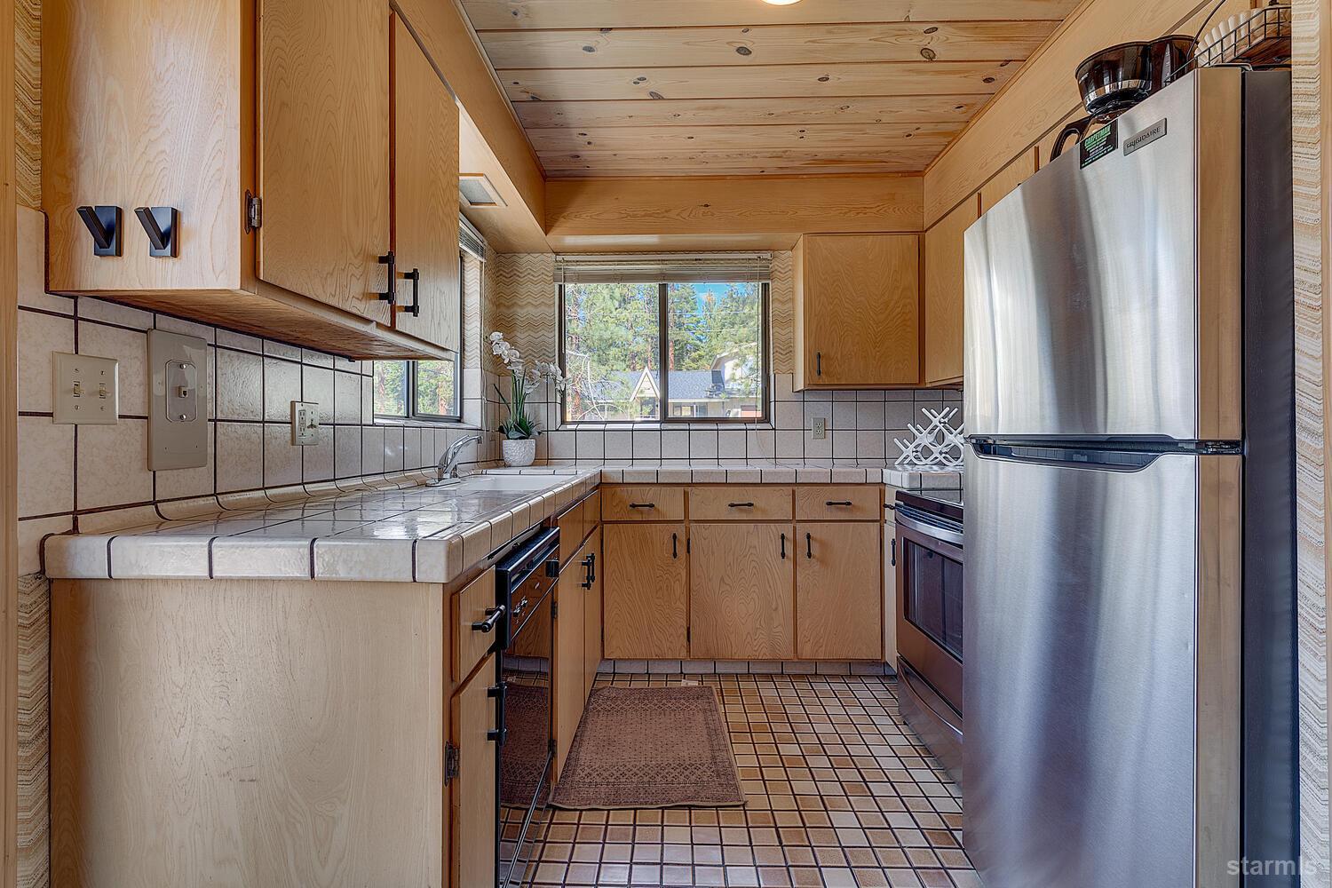 345 Granite Drive Stateline, NV 89449 - Photo 9 of 24 a kitchen with a sink a refrigerator and cabinets