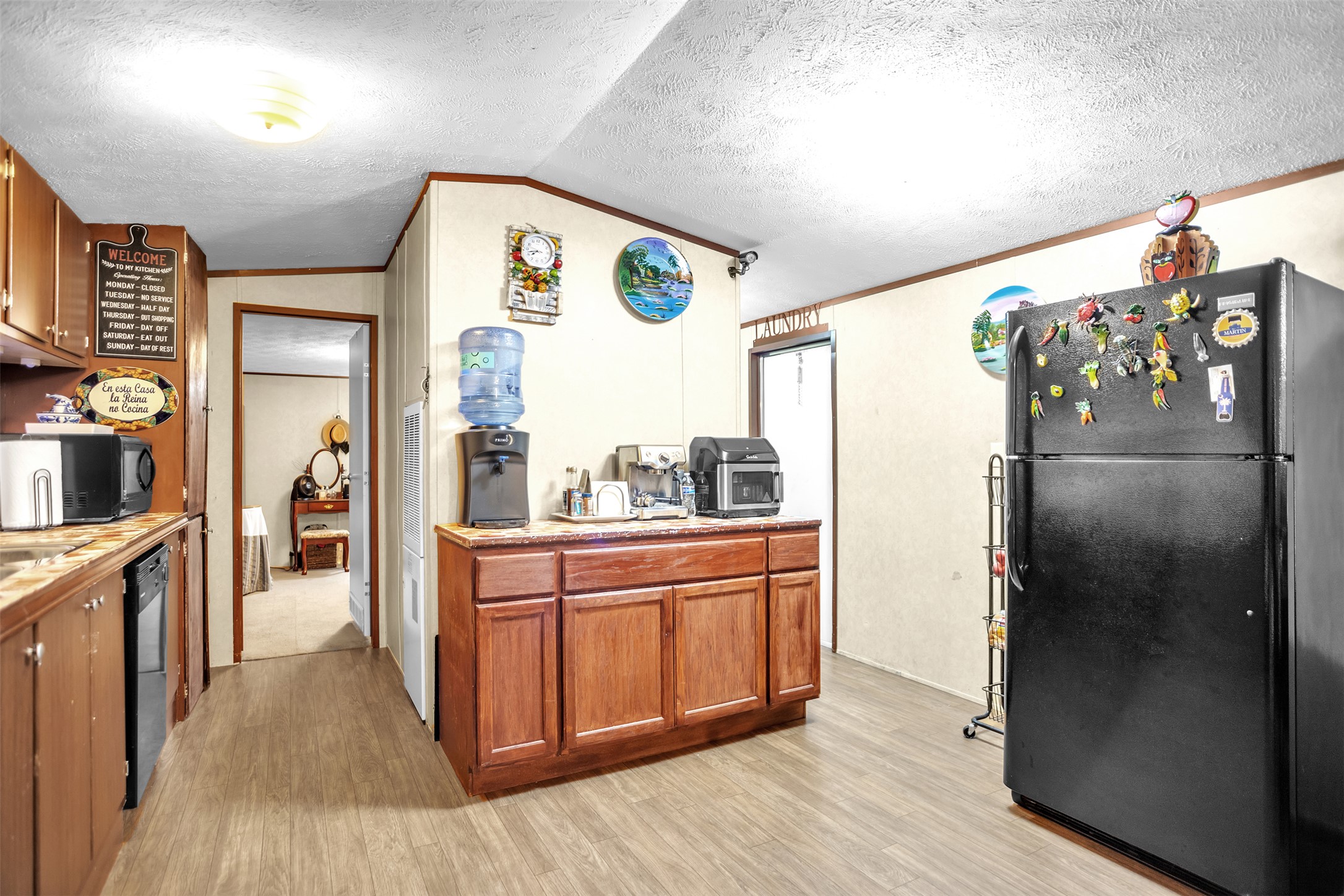 363 El Rey Drive Kyle, TX 78640 - Photo 12 of 40 Kitchen featuring black appliances, light countertops, light wood-type flooring, and ornamental molding