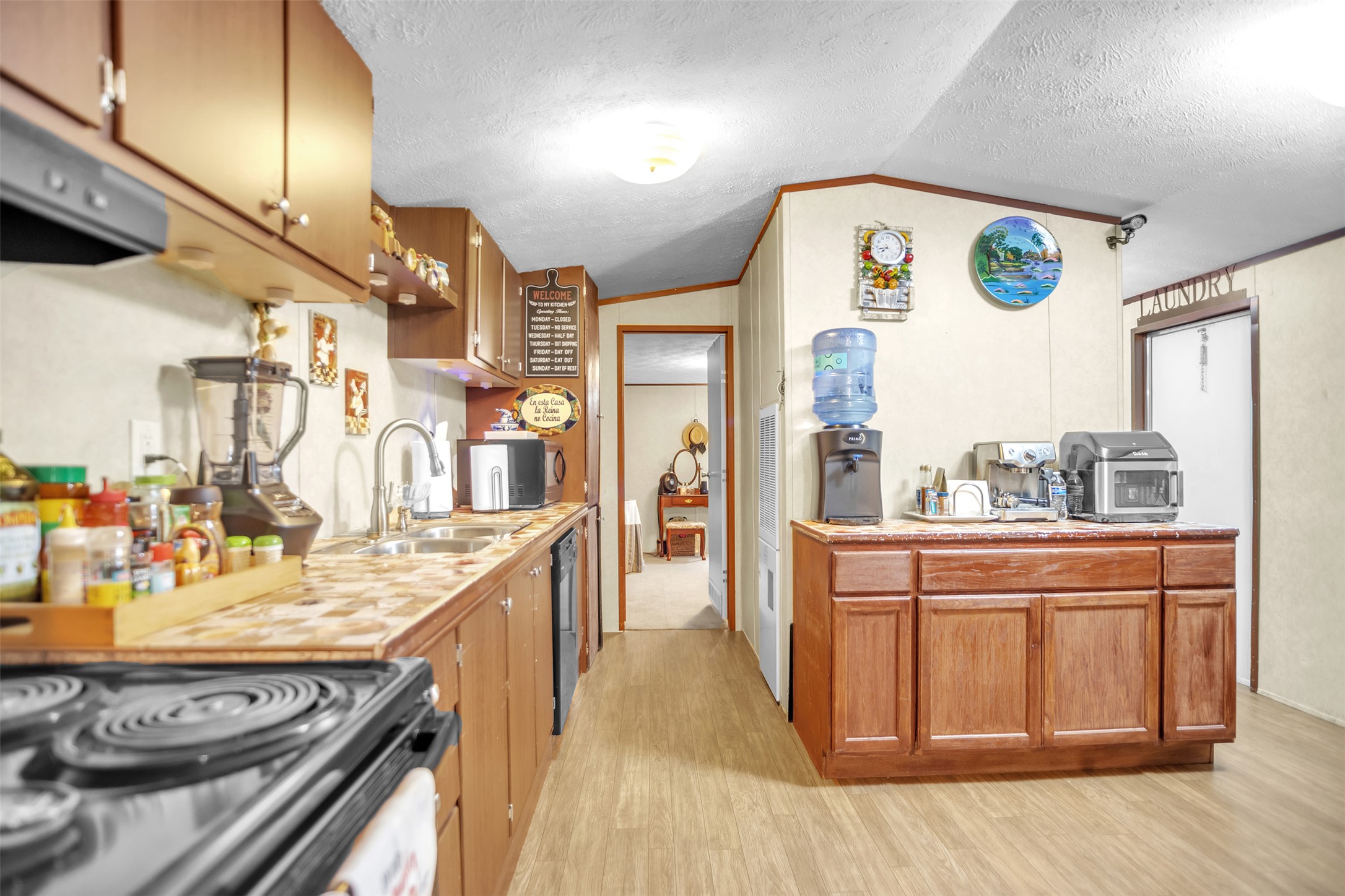 363 El Rey Drive Kyle, TX 78640 - Photo 13 of 40 Kitchen featuring light countertops, wood finish cabinets, light wood finished floors, ventilation hood, and ornamental molding