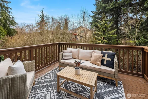 a balcony with wooden floor and outdoor seating