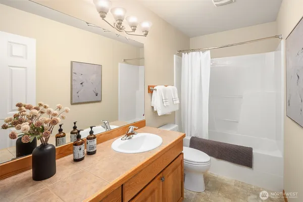 a bathroom with a granite countertop sink a toilet and shower curtain