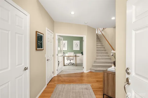 a view of a hallway with wooden floor windows and a livingroom