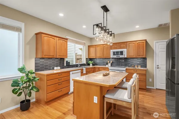 a kitchen with stainless steel appliances granite countertop a sink a stove and a refrigerator