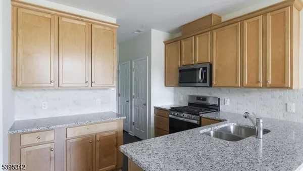 a kitchen with granite countertop wooden cabinets and a stove top oven